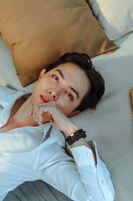 a man laying on a bed next to a basket of fruit